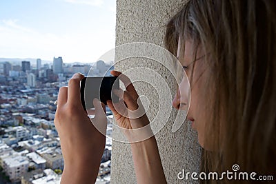 A tourist woman photographs a city with her mobile phone Stock Photo