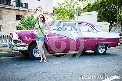 Tourist woman posing next to traditional cuban car, retro american oldtimer. Stock Photo