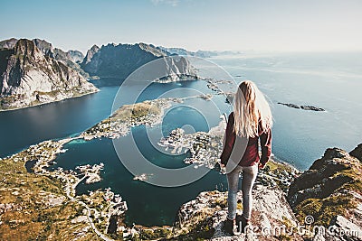 Tourist woman standing on cliff of Reinebringen mountain aerial view Stock Photo