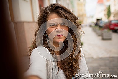 Tourist woman in the street on selfie shot showing gloomy face. Stock Photo