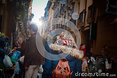 Woman walking trough a market and restaurants in San Sebastian. Pinchos and tapas food Editorial Stock Photo