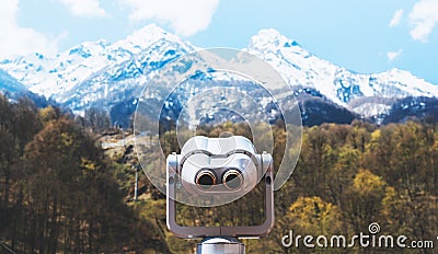 Touristic telescope look at the city with view snow mountains, closeup metal binocular on background viewpoint observe vision Stock Photo