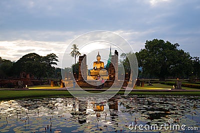 Tourists at the ancient sculpture of seated Buddha in the evening twilight. Historical Park of Sukhothai, Thailand Editorial Stock Photo