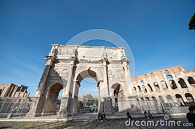 Tourists at the Arch of Constantine. Triumphal arch and Colosseum in the background in Rome, Italy in 2023 Editorial Stock Photo