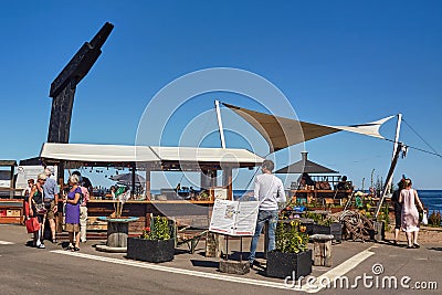 Tourists in a bar at the Baltic Sea harbor in Svaneke. Editorial Stock Photo