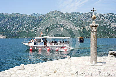 Tourists on a boat docking on the island of Lady of the rock Editorial Stock Photo