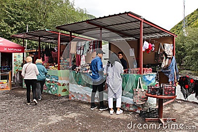 Tourists buying some Georgian food from a road side shop next to the black and white Aragvi river Editorial Stock Photo