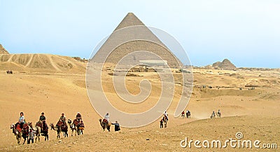 Tourists on camels in front of the Pyramid of Cheops Editorial Stock Photo