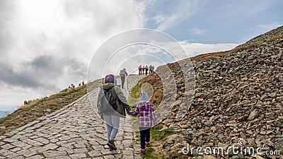 Tourists with child on the trail in the Karkonosze Mountains, Sniezka summit 1603 m n.p.m., Poland, Karkonosze National Park, Tour Editorial Stock Photo