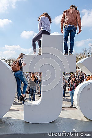 Tourists climb on the iAmsterdam sign at the Museum Square, in A Editorial Stock Photo