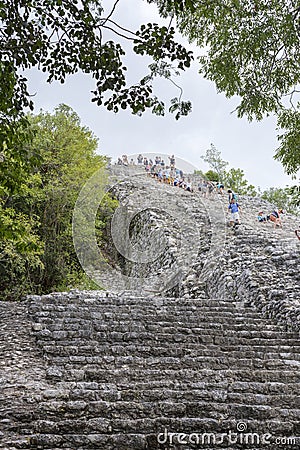 Tourists climb the Pyramid Nohoch Mul along the guiding rope at the Mayan Coba Ruins, Mexico Editorial Stock Photo