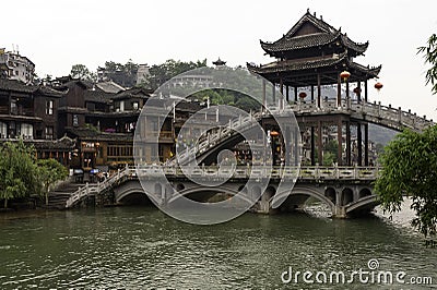 Tourists cross the Nanhua Bridge over the Tuo Jiang River to see more of Fenghuang Ancient City in Tibet, China Editorial Stock Photo