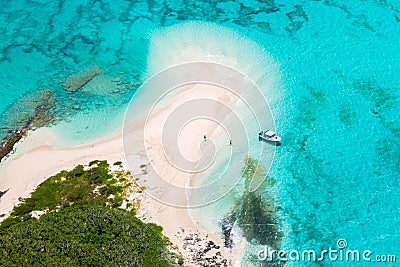 Aerial view of tourists, jet boat, idyllic empty sandy beach, remote island, azure turquoise blue lagoon, New Caledonia, Oceania. Stock Photo