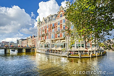 Tourists enjoy a relaxing waterfront lunch at a hotel on one of the major canals near the Museum District in Amsterdam Netherlands Editorial Stock Photo