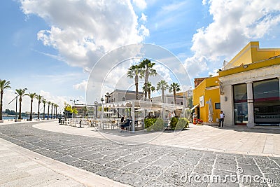 Tourists enjoy a sunny summer day on the waterfront boardwalk at the port city of Brindisi Italy Editorial Stock Photo