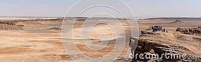 Tourists enjoying the scenic view of the Sahara desert from mount Gara Medouar Stock Photo