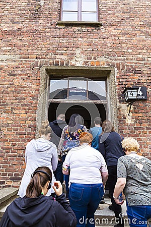 Tourists entering with guild in Auschwitz concentration camp complex museum Stock Photo