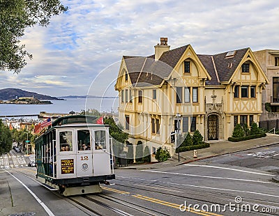Tourists on the iconic cable car at the top of Hyde Street, overlooking the bay and Alcatraz prison, San Francisco, USA Editorial Stock Photo