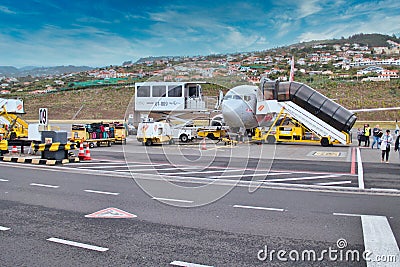 Tourists leave a Jet2 plane while crews arrive to offload luggage and to fuel and service the plane ready for its next flight. Editorial Stock Photo