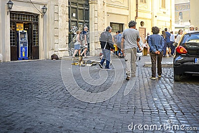 Tourists and local Italians pass by two panhandling street dogs in Trastevere district of Rome Italy Editorial Stock Photo