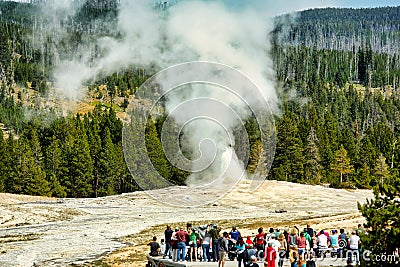 Tourists looking at the Old Faithful Geyser. Yellowstone National Park. Wyoming. USA. Editorial Stock Photo