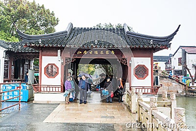 Tourists at the main entrance of wooden historic buildings in Zhujiajiao in a rainy day, an ancient water town in Shanghai, built Editorial Stock Photo