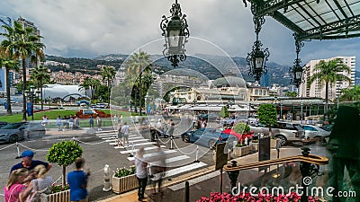 Tourists make pictures near expensive cars and famous Casino building timelapse in Monte Carlo in Monaco. Editorial Stock Photo