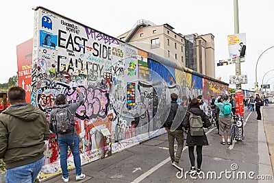 Tourists making photos of the art paintings on the ruins from Berlin Wall Stock Photo