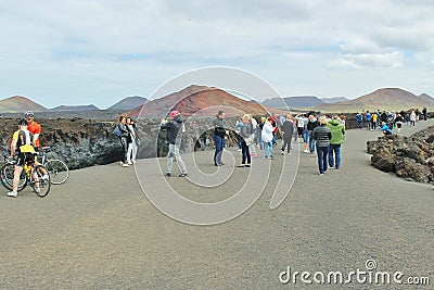 Tourists next to the rocky coast of Los Hervideros. Editorial Stock Photo