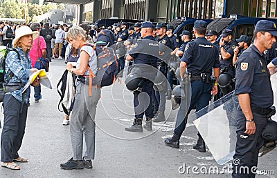 Tourists pass next to Police controls the access to international Sants rails station in Barcelona Editorial Stock Photo