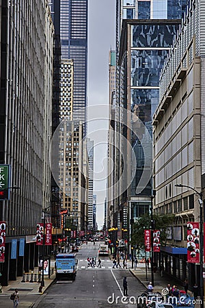 Tourists and pedestrians on Chicago street corridor between skyscraper buildings on gloomy day Editorial Stock Photo