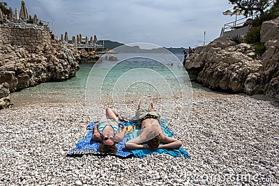 Tourists relax on the rock beach in the Mediterranean seaside town of Kas in Turkey. Editorial Stock Photo