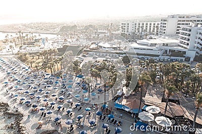 Tourists relaxing on Nissi beach with hotels and resorts in background. Ayia Napa, Cyprus Stock Photo