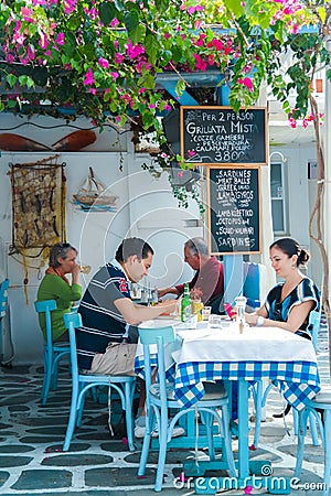 Tourists at restaurant on the beach near the four famous windmill Editorial Stock Photo