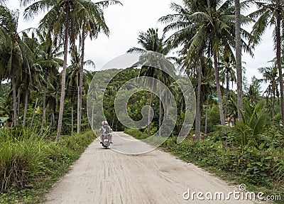 Tourists ridding a scooter on a country road, Thailand Editorial Stock Photo