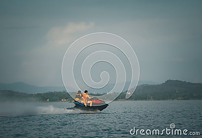 Tourists riding jet skis High-speed in sea or river with water spray People ride water scooters . Stock Photo