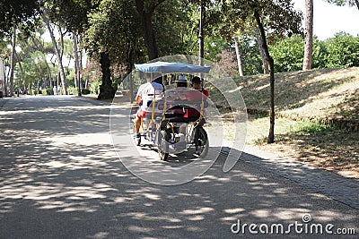 Tourists riding a rickshaw in Villa Borghese, Rome Editorial Stock Photo
