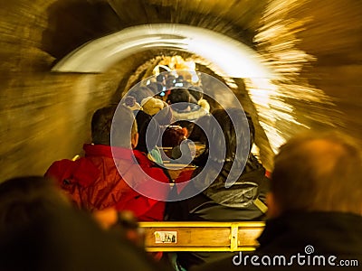 Tourists riding the train through the Postojna cave Editorial Stock Photo