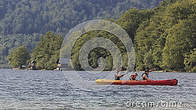Tourists rowing on a canoe on Bohinj lake in Slovenia Editorial Stock Photo