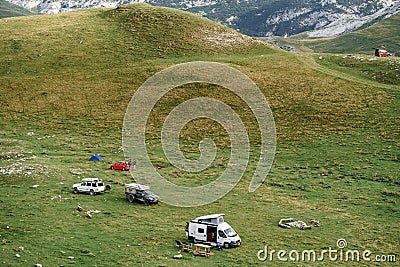 Tourists set up a car camp in the mountains, on the green grass. Montenegro, Durmitor National Park. Stock Photo