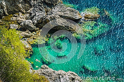 Tourists shorkling between Rocks in Azure Bay of Beautiful Paleokastritsa in Corfu Island, Greece Stock Photo