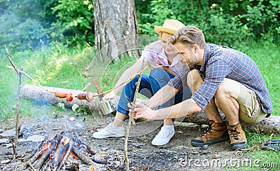 Tourists sit log near bonfire taking photo on smartphone. Couple on vacation capture moment. Man taking photo of bonfire Stock Photo