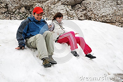 Tourists sliding on snowfield. Stock Photo