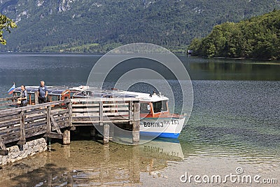 Tourists on a small boat in lake Bohinj, a famous destination not far from lake Bled. Editorial Stock Photo