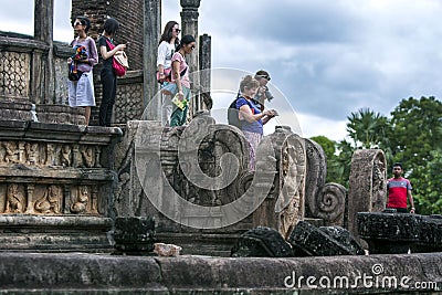 Tourists stand on the stairway of the Vatadage which forms part of the Quadrangle at the ancient Sri Lankan capital at Editorial Stock Photo