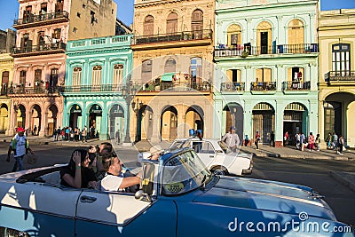 Havana, Cuba, tourists taking photos out of classic car in street with buildings in colonial style architecture Editorial Stock Photo