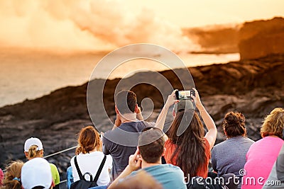 Tourists taking photos at Kalapana lava viewing area. Lava pouring into the ocean creating a huge poisonous plume of smoke at Hawa Editorial Stock Photo