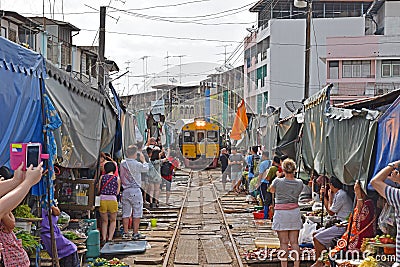 Tourists taking pictures of the incoming train while vendors cleared all their fresh produce Editorial Stock Photo