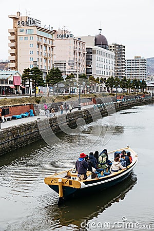 Tourists travel by boat in the Otaru Canal in winter in Hokkaido, Japan Editorial Stock Photo