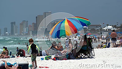Tourists under a colorful beach umbrella Editorial Stock Photo